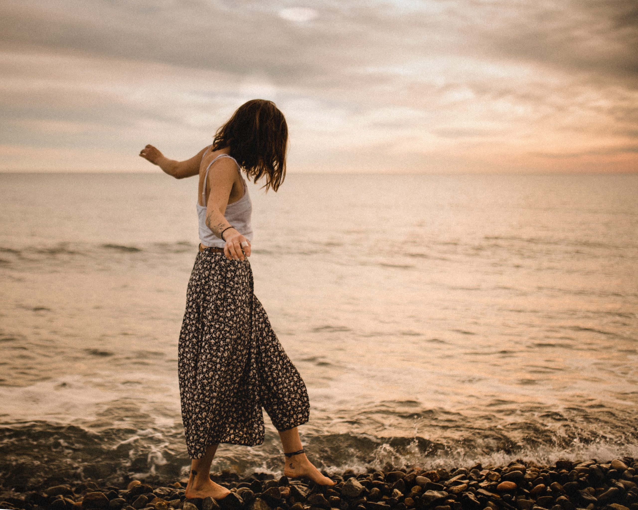 Woman Walking On Pebble Beach
