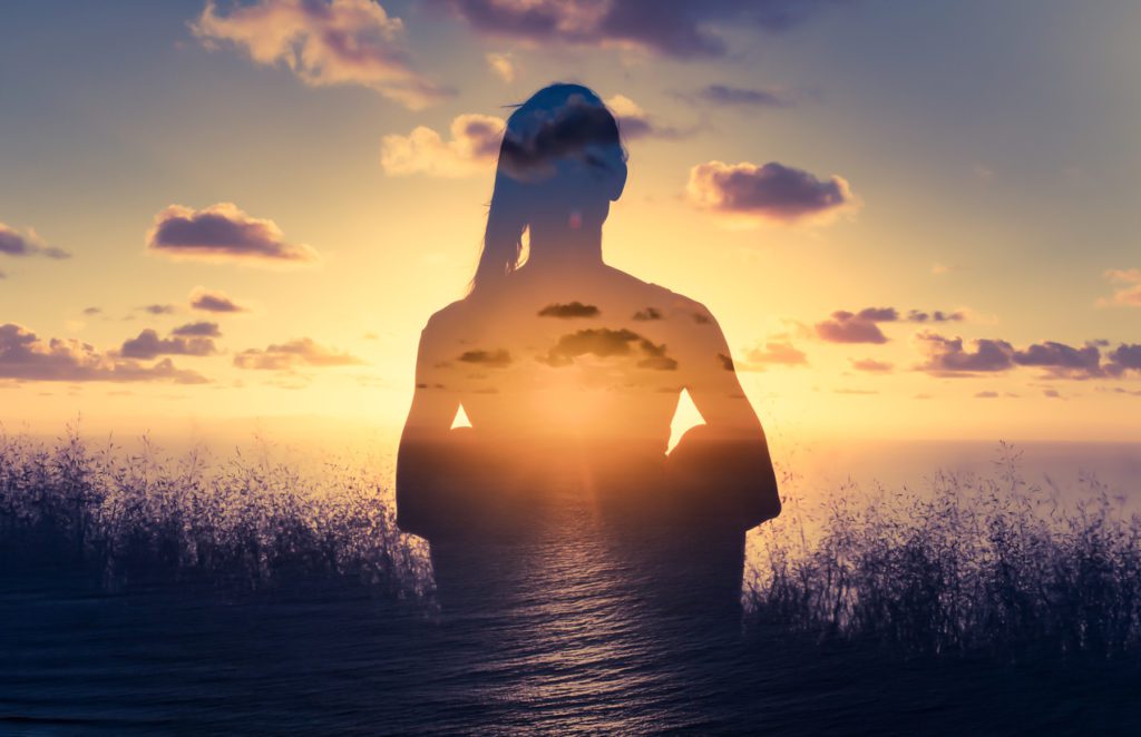 Woman Meditating At Sunset